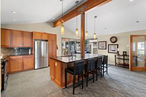 Kent apartment for rent - A kitchen with wooden cabinets and a large island with chairs.