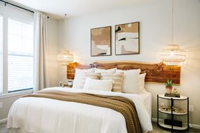 Greenville apartment for rent - A bedroom with a large bed and two wall lamps.