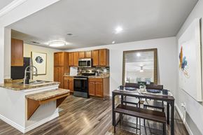 San Antonio apartment for rent - A kitchen with a table and chairs in the foreground and a counter with a sink in the background.