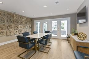 Charlotte apartment for rent - a modern room with a table and chairs and a television on the wall at Canopy apartments in South Charlotte