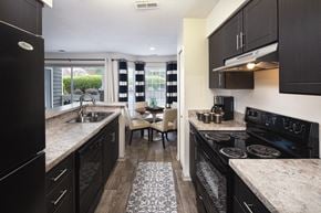 Charlotte apartment for rent - A kitchen with black cabinets and a granite countertop.