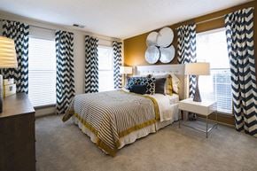 Charlotte apartment for rent - A bedroom with a large bed and a chair.