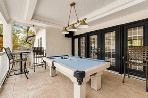 Sandy Springs apartment for rent - A pool table is in the middle of a room with a bar and chairs.