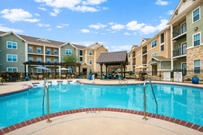 Converse apartment for rent - Apartments for Rent in Converse, TX - The Heights at Converse - Resort-Style Swimming Pool With Lounge Seating, Covered Cabana, Wooden Pergolas, Metal Fence, and Apartment Buildings.