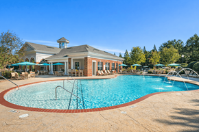 Greenville apartment for rent - A large swimming pool in front of a building with a gazebo.