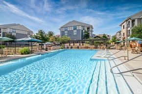 San Antonio apartment for rent - Dog-Friendly Apartments in Stone Oak, TX - Encore 281 Apartment Homes - Resort-Style Pool With Lounge Seating, Shaded Umbrellas, Water Features, And Apartment Buildings Under Bright Blue Sky. Bedroom