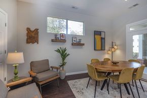 Raleigh apartment for rent - a dining area with a round wooden table and yellow chairs at Seasons at Umstead apartments in Raleigh