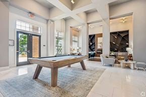 Greenville apartment for rent - A pool table is in the middle of a room with a blue rug.