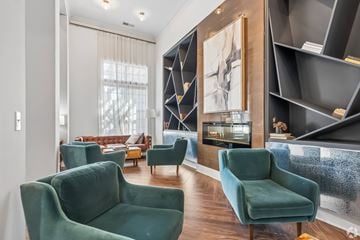 Greenville apartment for rent - A living room with green chairs and a large painting on the wall.