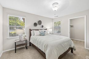 Central apartment for rent - A bedroom with a bed, nightstand, and window.