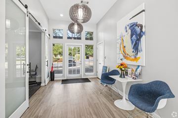 Central apartment for rent - A modern room with a white table and blue chairs.