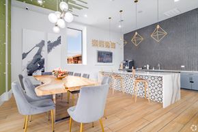 San Antonio apartment for rent - A modern community kitchen and dining room with a wooden table and grey chairs.