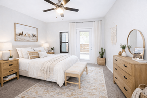 San Antonio townhouse for rent - A bedroom with a large bed, a bench, and a rug.