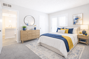 Duluth apartment for rent - 2-Bedroom Apartments in Duluth, GA - The Eclipse - Bedroom With King Bed, Blue And Yellow Accent Pillows, Nightstand, Dresser, Area Rug, And Large Windows.