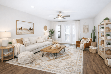 San Antonio townhouse for rent - A living room with a white couch, a wooden coffee table, and a painting of a horse-drawn carriage on the wall.