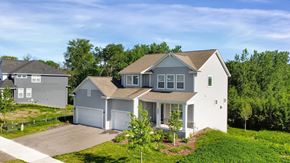 Blaine house for rent - A large white house with a grey roof and a garage is surrounded by greenery.