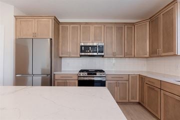 Blaine house for rent - A kitchen with wooden cabinets and a marble countertop.