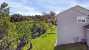 Blaine house for rent - A house with a grey siding is surrounded by a green lawn and trees.