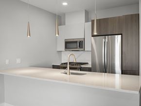 Somerville apartment for rent - A modern kitchen with a stainless steel refrigerator and a white countertop.