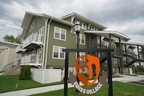 Louisville apartment for rent - A sign for Swiss Village stands in front of apartment buildings.