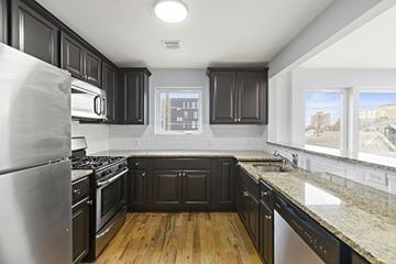 Newark apartment for rent - A kitchen with black cabinets and a stainless steel refrigerator.