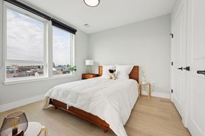 Newark apartment for rent - A bedroom with a large bed and a view of the city.