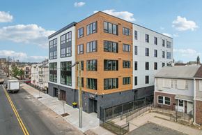 Newark apartment for rent - A street view of a city with a large building in the middle.