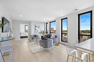Newark apartment for rent - A modern living room with a grey couch and a glass table.