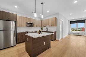 Newark apartment for rent - A modern kitchen with wooden cabinets and a central island.