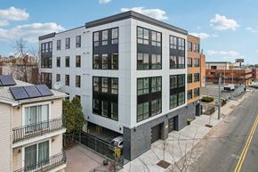 Newark apartment for rent - A modern building with a balcony and solar panels on the roof.