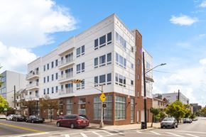 Newark apartment for rent - A white building with a red car in front of it.