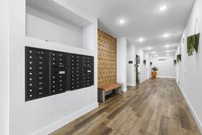 Newark apartment for rent - a long hallway with white walls and wood floors and a locker on the wall