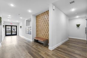 Newark apartment for rent - a hallway with white walls and wood floors and a bench