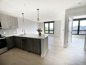 Newark apartment for rent - a kitchen and living room with white walls and wood floors