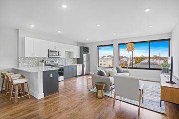 Newark apartment for rent - A modern kitchen with a dining area and a view of the city.
