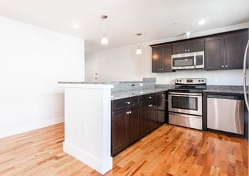 Newark apartment for rent - A kitchen with dark brown cabinets and stainless steel appliances.