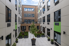 Newark apartment for rent - A courtyard with a tree surrounded by planters and buildings.
