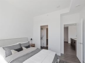 Calgary apartment for rent - the master bedroom has a large bed and a walk in closet