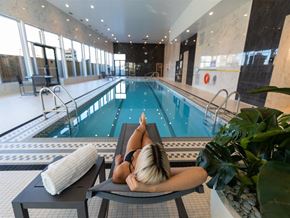 Calgary apartment for rent - a woman laying on a lounge chair next to a swimming pool