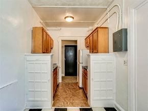 Baltimore apartment for rent - a kitchen with white cabinets and a door to a hallway