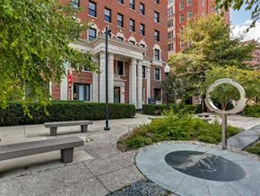 Baltimore apartment for rent - a park with benches and a fountain in front of a building