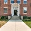Baltimore apartment for rent - the front of a brick building with a white door and stairs