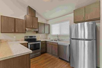 Post Falls apartment for rent - A kitchen with a stainless steel refrigerator, oven, and sink.