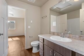Post Falls apartment for rent - A bathroom with a toilet, sink, and mirror.