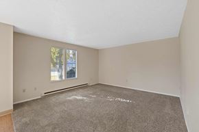 Spokane apartment for rent - an empty living room with carpet and a window