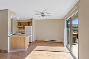 Spokane apartment for rent - an empty living room with a kitchen and a ceiling fan