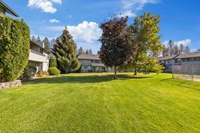 Spokane apartment for rent - a large yard with houses in the background and trees