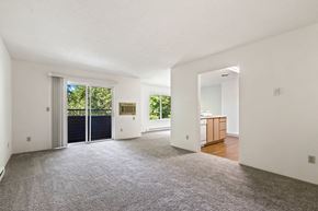 Spokane Valley apartment for rent - a living room with a door to a kitchen and a carpeted floor
