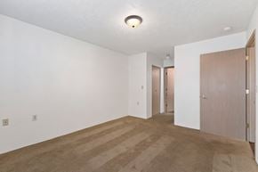 Spokane Valley apartment for rent - an empty living room with white walls and a door to a hallway