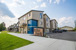 Post Falls apartment for rent - a sign sits on the sidewalk in front of a row of houses